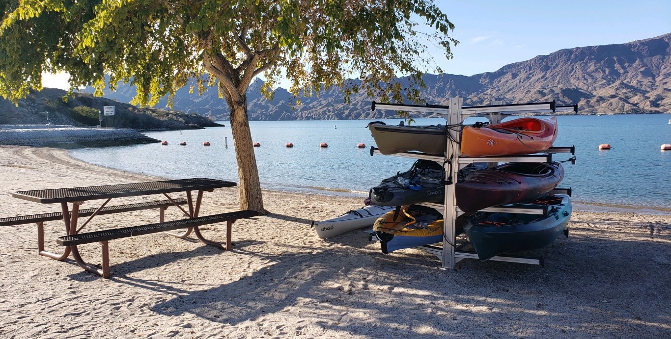 Kayaks stacked for rent on the white sand beach at Cattail Cove State Park