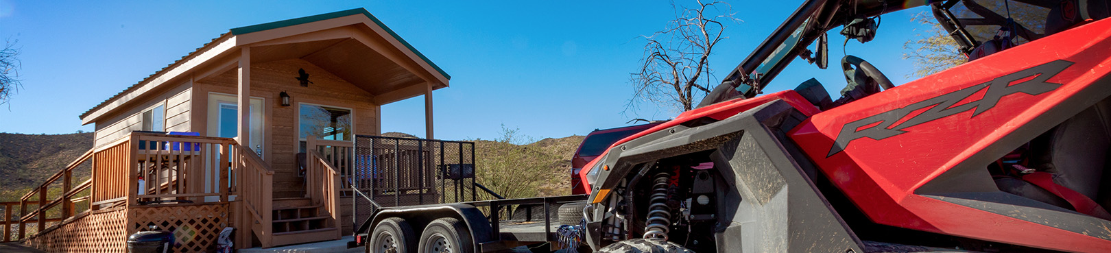 A park cabin with a red side by side vehicle parked in front.