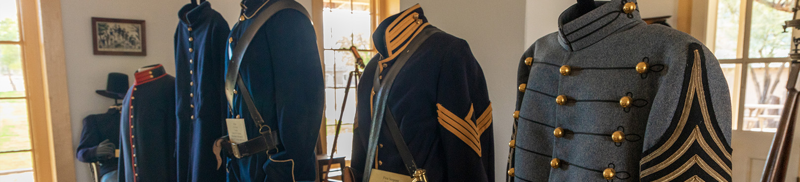 A row of historic military uniforms on display at Colorado River State Historic Park