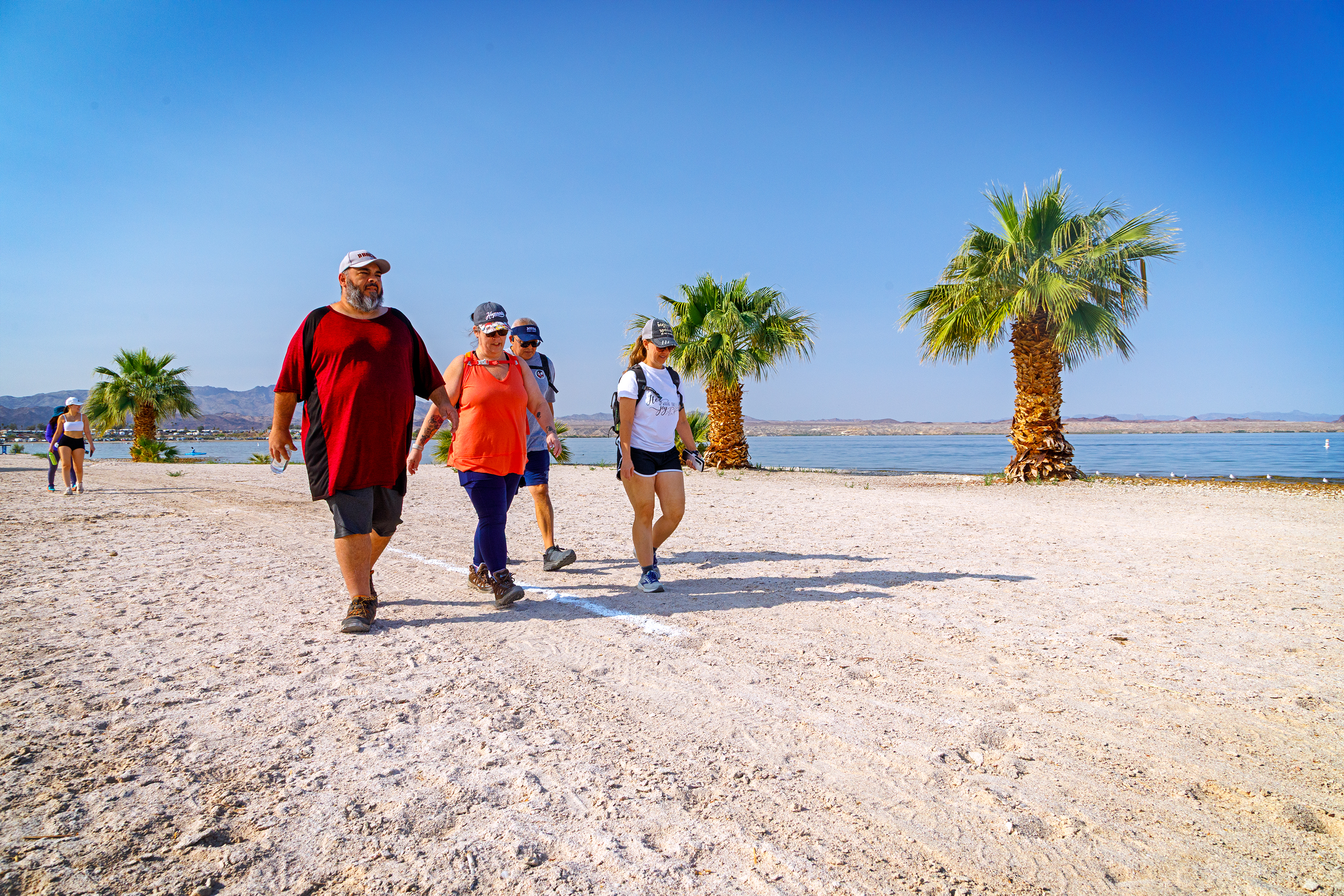 A group of state employees walk along the beach at Lake Havasu State Park