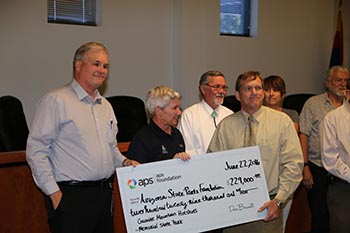 APS presents a large check to the executive director for the park