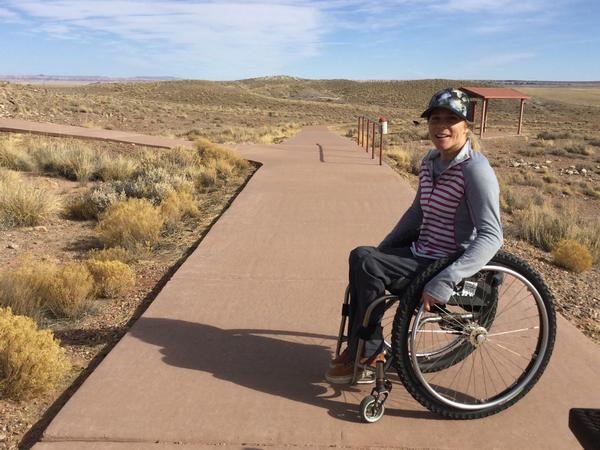 ADA Trail Accessibility. Woman in a wheelchair poses for a pic on an accessible trail. 