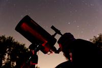 A visitor looks through a telescope during a Star Party