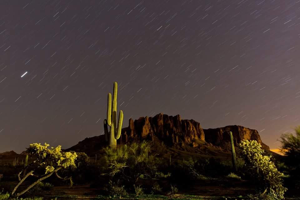 The Superstition Mountain range under a starry night sky.