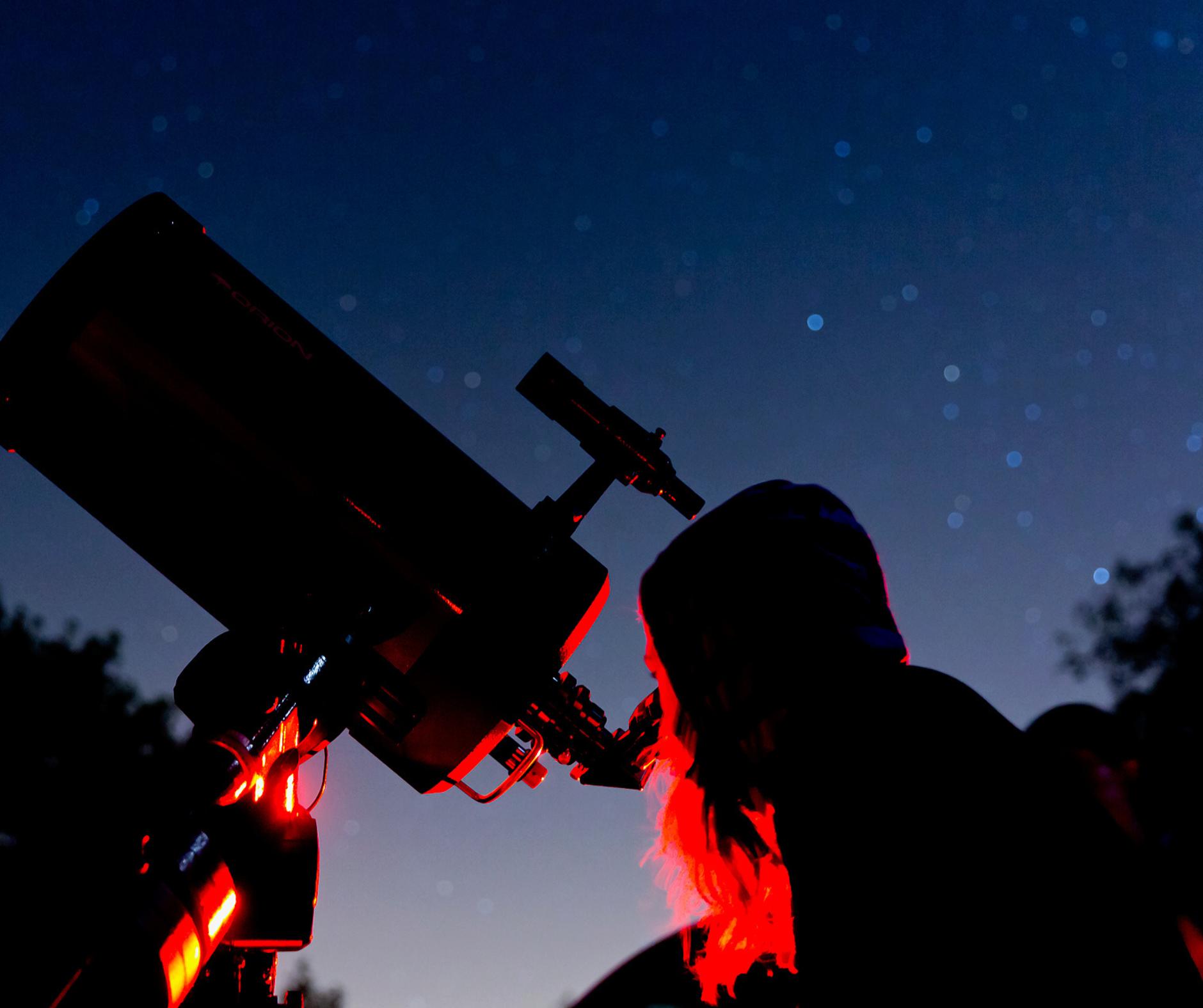 A person looking through a telescope with a starry sky in the background.